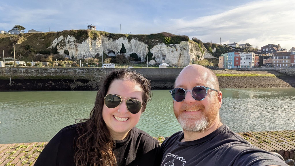 Luxury travel agent Carolyn Kulb posing in front of white limestone cliffs in Dieppe Normandy for a selfie with her husband